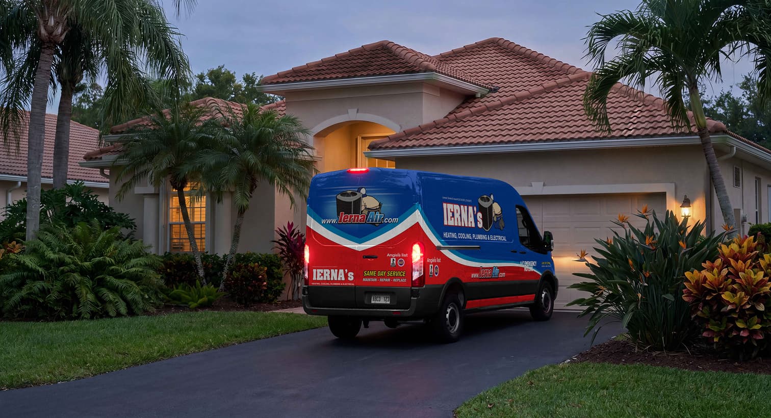 An IERNA's service van parked in a residential driveway at dusk, arriving to provide emergency AC repair services.