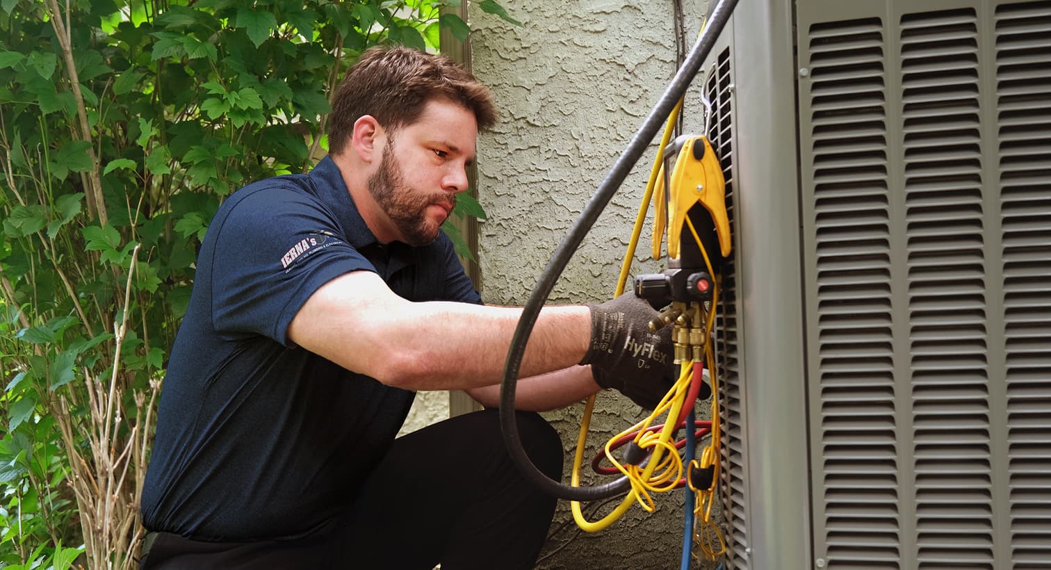 A professional IERNA's HVAC technician inspecting an outdoor central air conditioning unit to provide residential AC repair and diagnostic services.