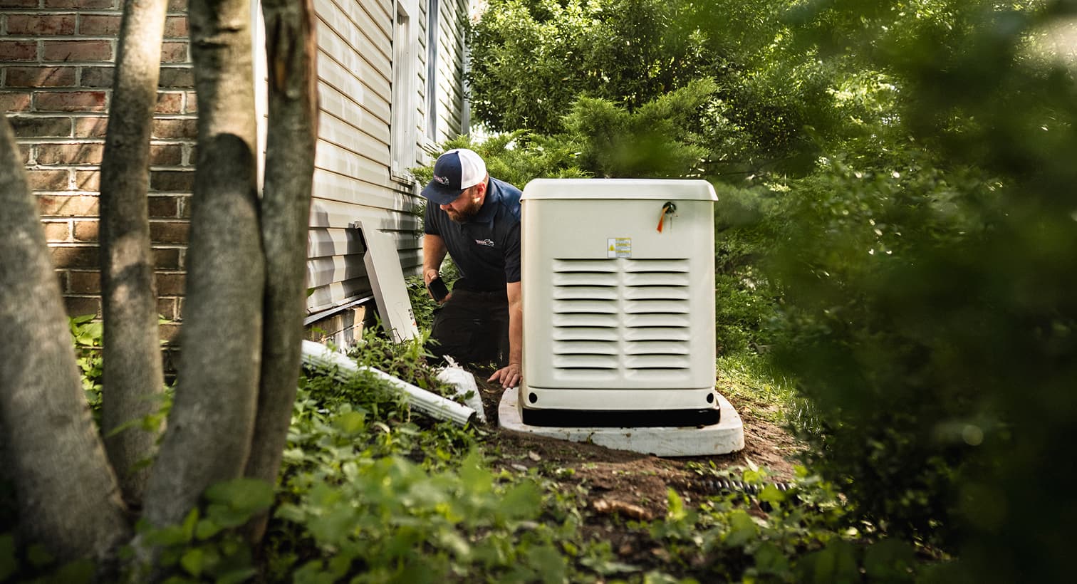 A professional IERNA's technician inspects a large, beige whole-home standby generator installed on a concrete pad outside a residential house.