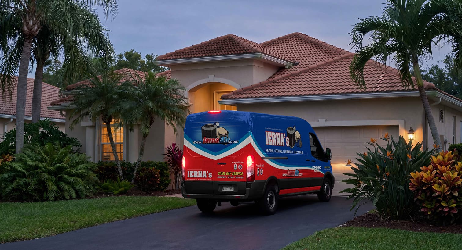 An IERNA'S service van parked in a residential driveway at night, arriving to provide emergency plumbing services.